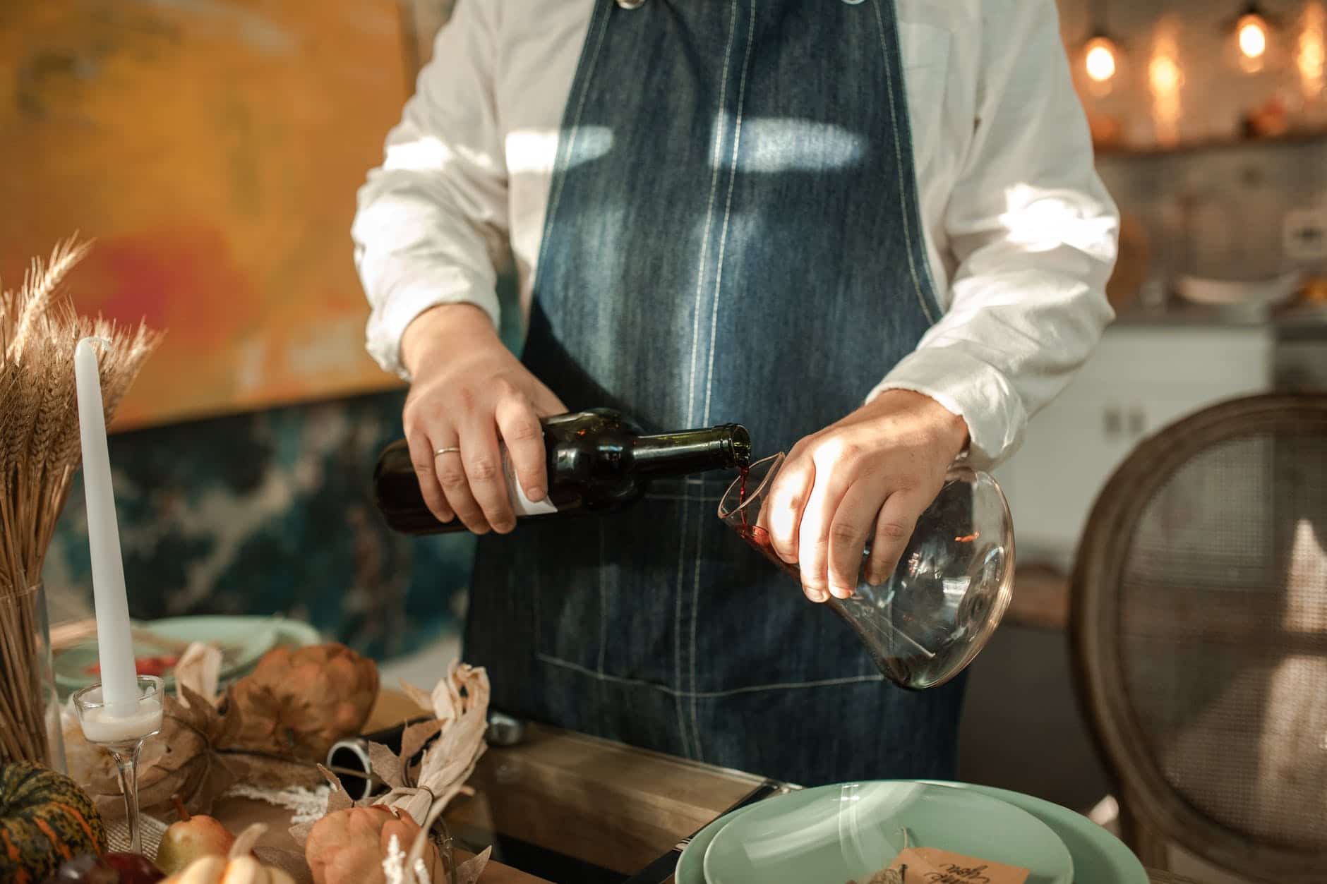 person in white long sleeve shirt holding black bottle